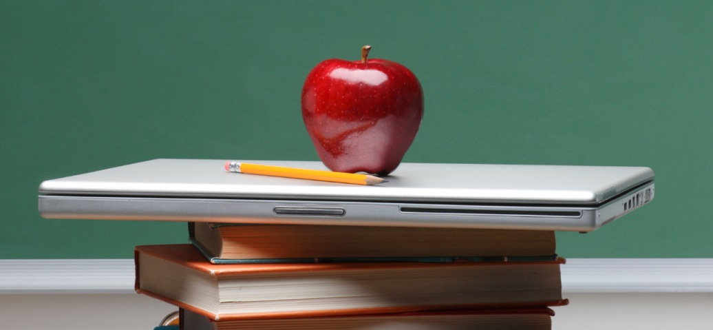 An image showing a stack of books with an apple on top, indicating education