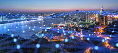 Connected city skyline at dusk with a digital network overlay representing smart infrastructure and secure connectivity.