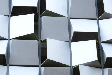 A 3D geometric wall pattern with angled panels creating depth and shadow.