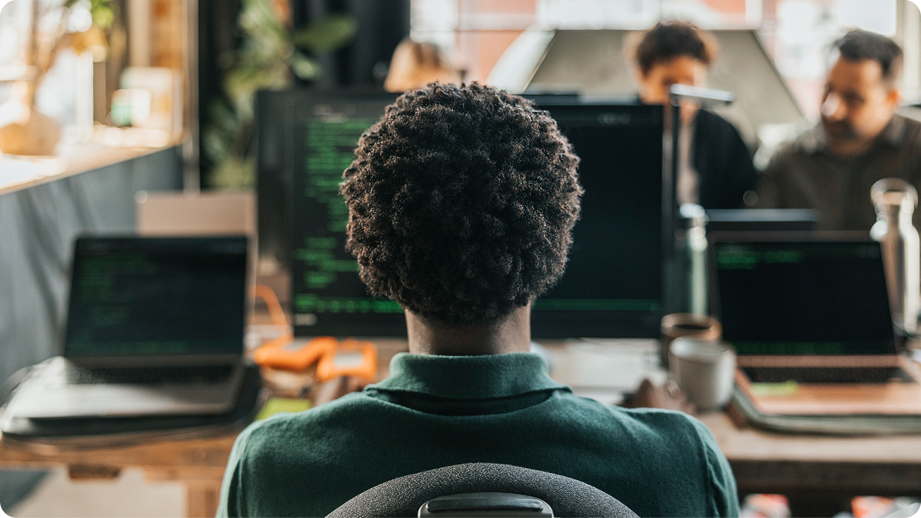 Person working at a computer in a collaborative office environment.