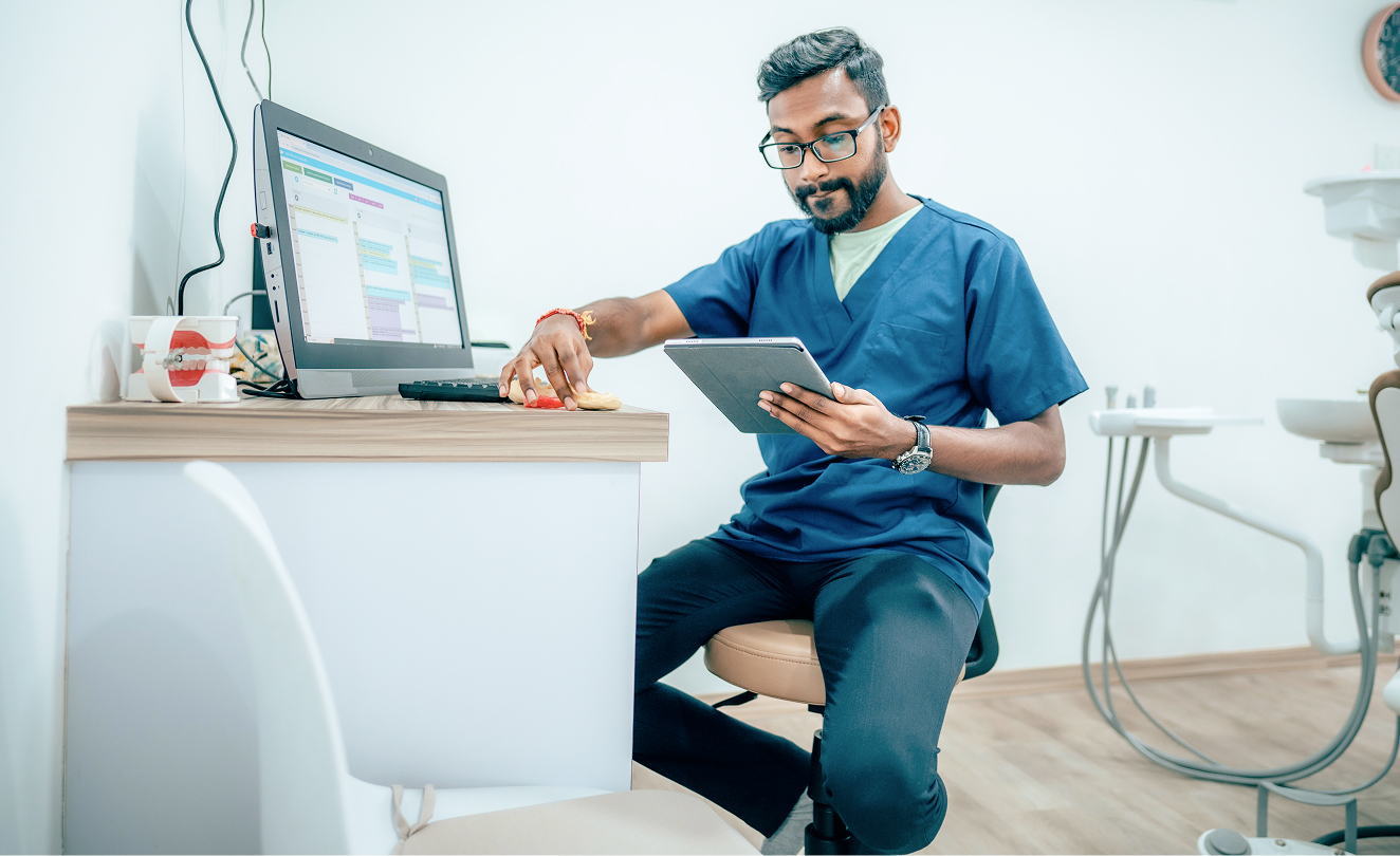 Healthcare professional using a tablet to review information in a clinical office.