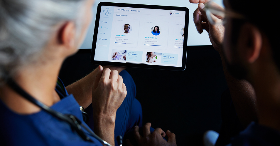 Healthcare professionals collaborating while reviewing patient information on a digital display.