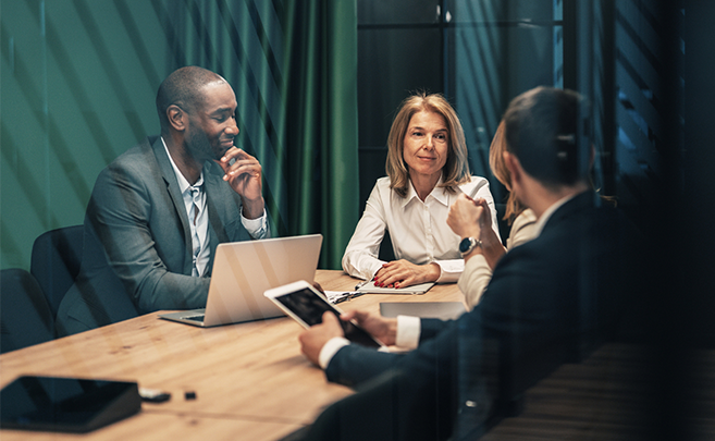 Diverse business colleagues collaborating around a wooden table in a meeting room.