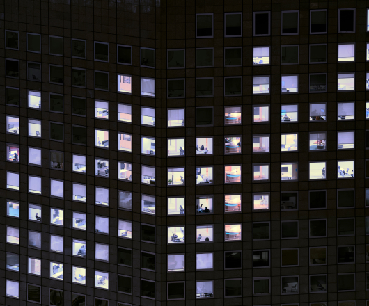 Nighttime view of a high-rise building with numerous illuminated windows.