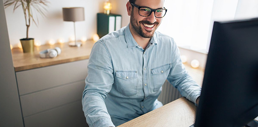 man happily working infront of a desktop