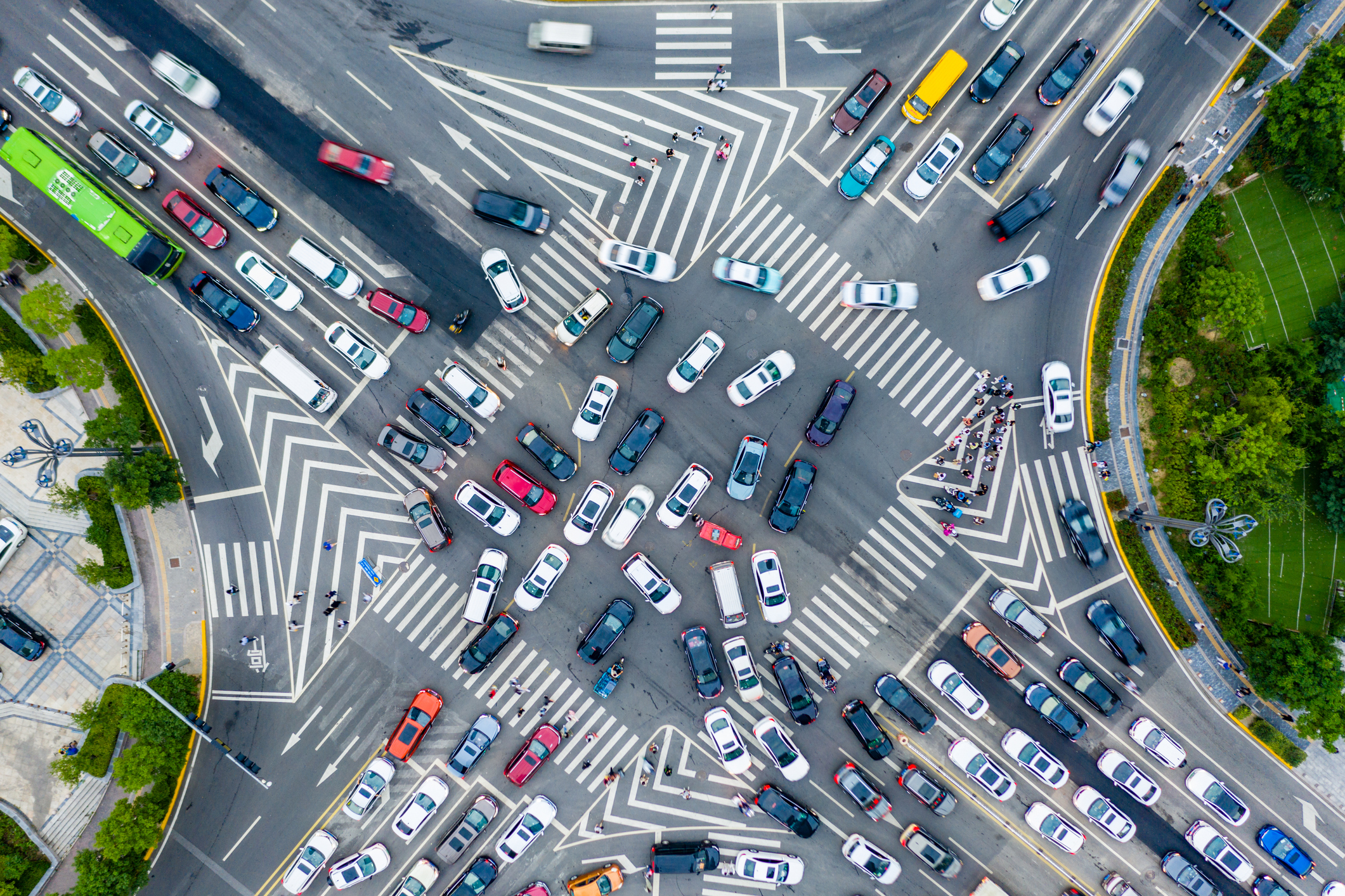 A bird’s eye view of a chaotic, multi-lane city intersection crisscrossed with bold white markings and packed with cars converging from every direction.