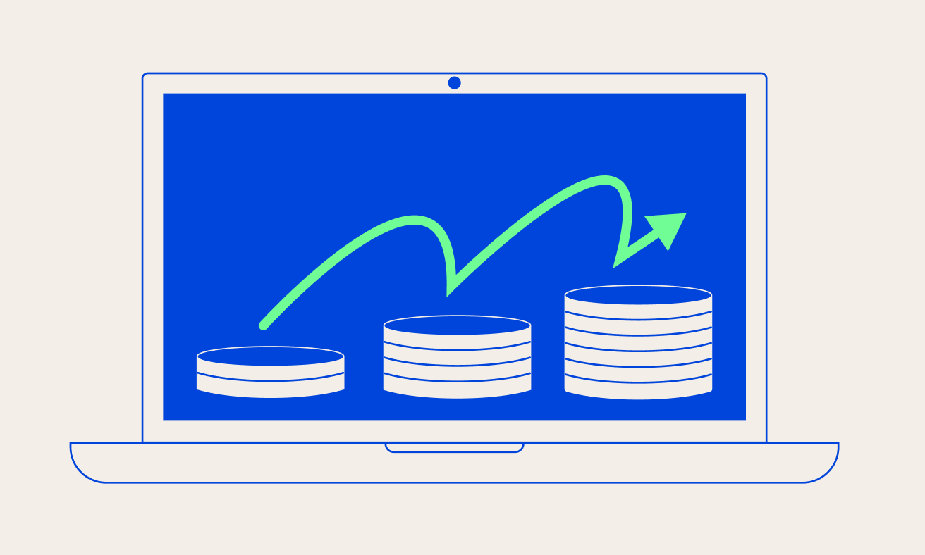 Laptop displaying a rising arrow graph above stacked coins on the screen.