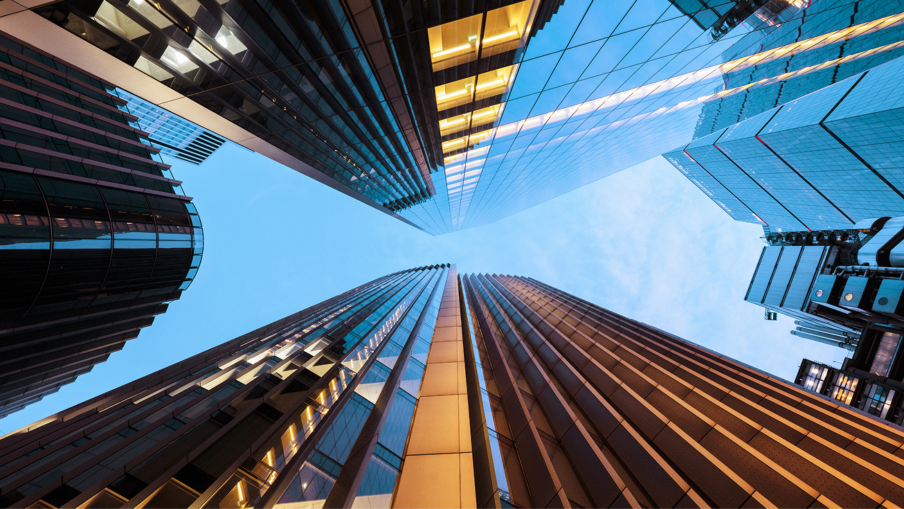 City skyline reflected on water, representing the financial services industry.