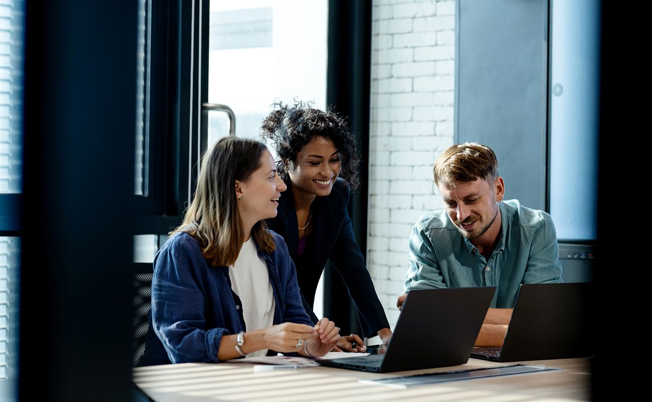Three colleagues collaborating in an office meeting to improve productivity.
